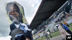A supporter wears a poster on his head of Ivory Coast Laurent Gbagbo during a rally at a stadium in Bouake ahead of the 31 Oct 2010 elections (File)
