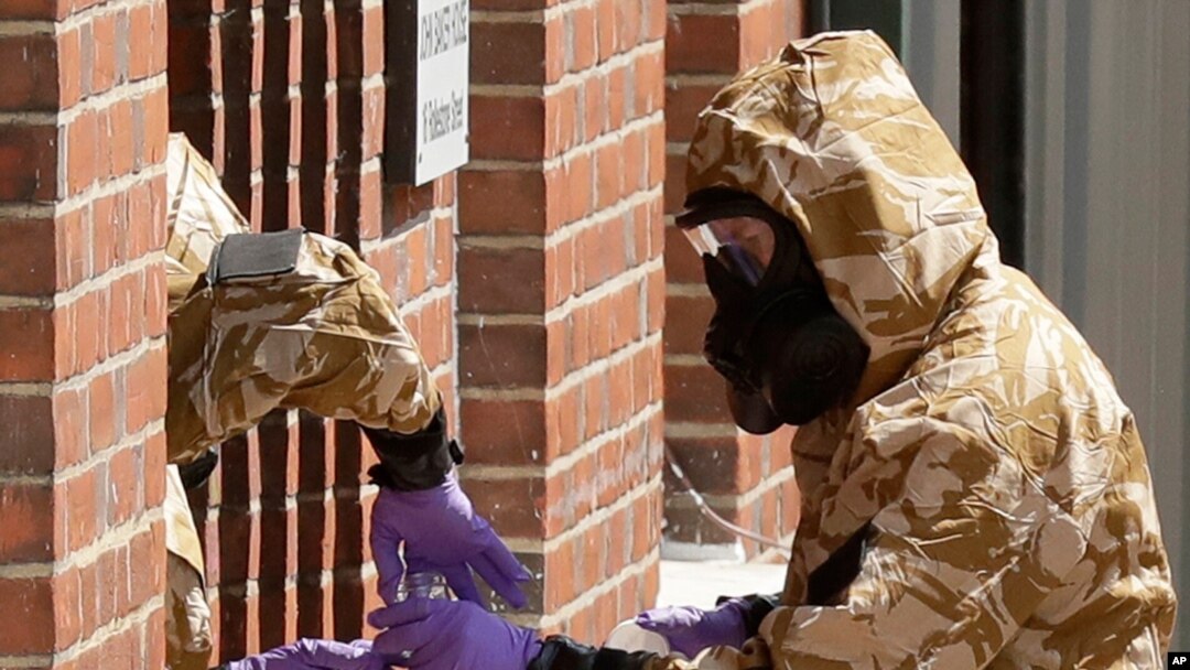 FILE - Specialist team members wear military protective suits during Novichok nerve agent cleanup operations in Salisbury, England, July 6, 2018.