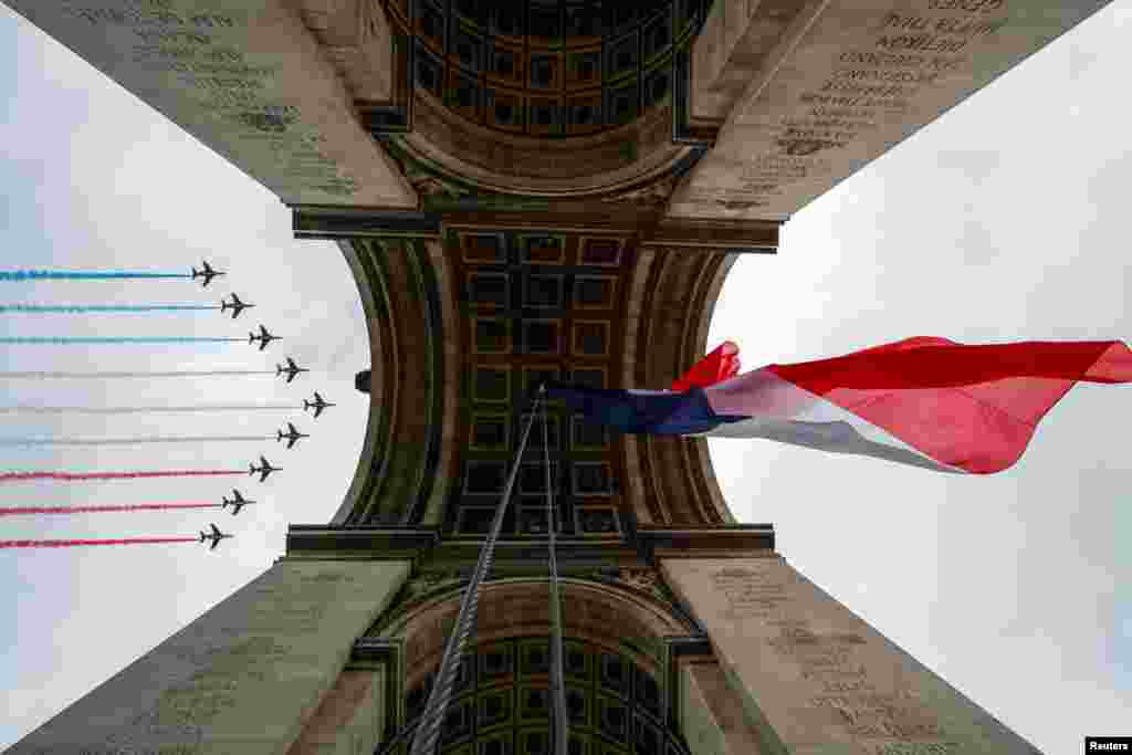 Alpha jets from the French Air Force Patrouille de France fly over the Arc de Triomphe during Bastille Day celebrations in Paris.