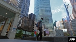 Seorang pria berjalan di kawasan bisnis di Raffles Place yang lengang akibat tindakan preventif pemerintah untuk menanggulangi wabah pandemi COVID-19 di Singapura, 14 April 2020. (Foto: dok).