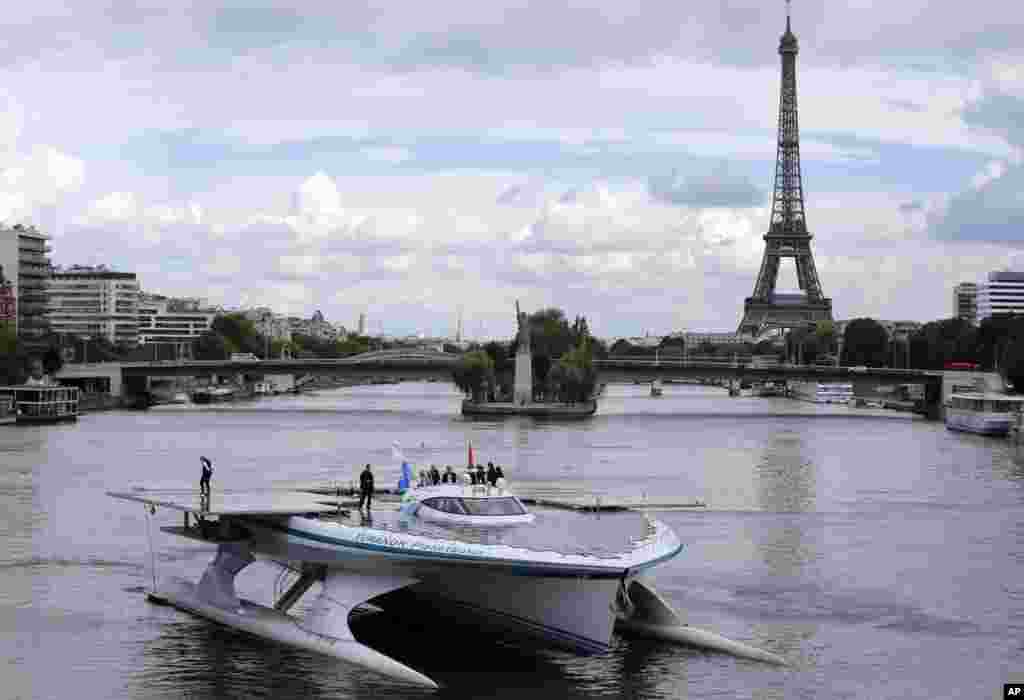 Turanor PlanetSolar, kapal tenaga surya terbesar di dunia, melakukan perjalanan di Sungai Seine di Paris, Perancis.