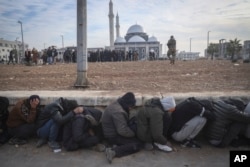 Pobunjenici privode vladine vojnike u Homsu (Foto: AP/Omar Albam)