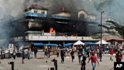 Pasar lokal dibakar oleh para demonstran selama aksi protes di kota Fakfak, provinsi Papua Barat, hari Rabu, 21 Agustus 2019. (Foto: AP/Beawiharta)