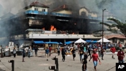 Sebuah pasar di Fakfak, Papua, terbakar saat unjuk rasa berlangsung, Rabu, 21 Agustus 2019. (Foto: AP)