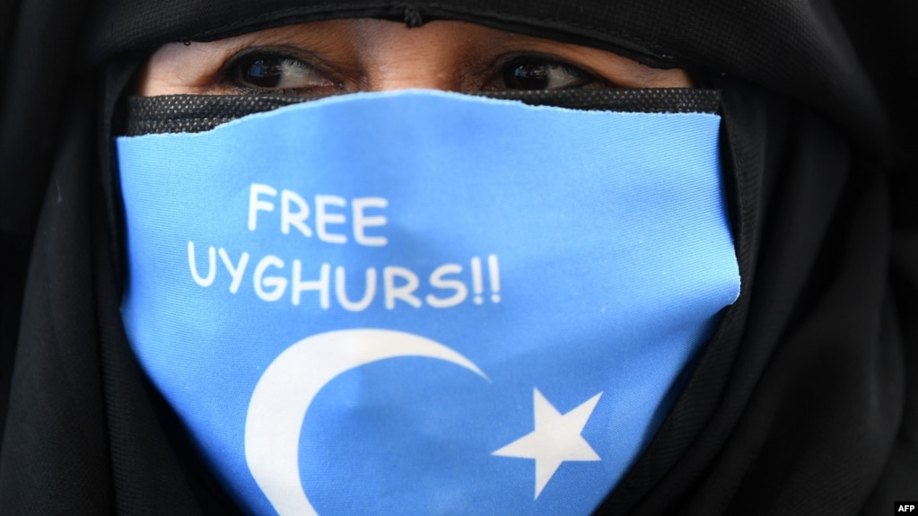 2021年3月8日担忧中国和土耳其批准引渡条约，一名维吾尔族妇女戴着印有东突厥斯坦国旗的口罩在中国驻伊斯坦布尔总领事馆附近示威(photo:VOA)