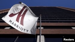 FILE - A Marriott flag hangs at the entrance of the New York Marriott Downtown hotel in Manhattan, New York.