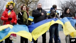 4月12日顿涅茨克亲乌克兰的示威者举着乌克兰国旗站在路边