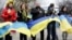 Pro-Ukrainian demonstrators holding Ukrainian flags stand along a street in Donetsk, Ukraine, April 12, 2014.