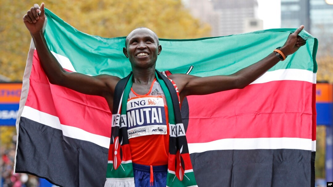 Geoffrey Mutai of Kenya holds the Kenyan flag after winning the men's division of the New York City Marathon, Nov. 3, 2013. 