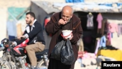 حلب کے نزدیک شام کے ایک کیمپ میں ایک پناہ گزیں امدادی خوراک کھا رہا ہے۔ 5 نومبر 2016