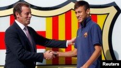 Presiden klub Barcelona Sandro Rosell (kiri) bersalaman dengan pemain asal Brazil Neymar, setelah penandatanganan kontrak Neymar dengan FC Barcelona (3 Juni 2013).