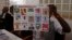 FILE - An election official shows a placard with different candidates during elections in Niamey, Niger, Feb 21, 2016.