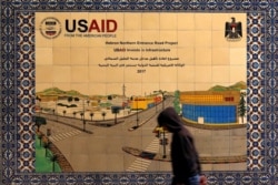 A Palestinian walks past a ceramic sign of a U.S. Agency for International Development (USAID) project in Hebron in the Israeli-occupied West Bank Jan. 31, 2019.