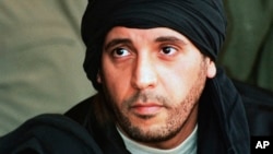 FILE - Hannibal Gadhafi, son of late Libyan leader Moammar Gadhafi, watches an elite military unit exercise in Zlitan, Libya. Judicial officials said on Dec. 21, 2015 that an arrest warrant has been issued for a former Lebanese MP over his alleged involvement in the kidnapping of Hannibal.