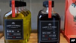 FILE - Bottles of maple syrup and olive oil infused with CBD marijuana extract are displayed for sale at the Village Bloomery medical cannabis dispensary in Vancouver, British Columbia, Sept. 25, 2018. 