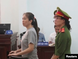 FILE - Prominent blogger Nguyen Ngoc Nhu Quynh, left, stands trial in the south central province of Khanh Hoa, Vietnam, June 29, 2017. She was accused of distorting government policies and defaming the Communist regime on her Facebook posts.