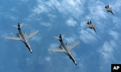 FILE - In this photo provided by South Korean Defense Ministry, U.S. Air Force B-1B bombers and South Korean fighter jets fly over the Korean Peninsula, June 20, 2017. China’s Foreign Ministry criticized the U.S. decision to send a pair of long-range bombers over the South China Sea on July 7, 2017, calling that a case of “flexing of military muscles” in a manner seen as threatening to Beijing.