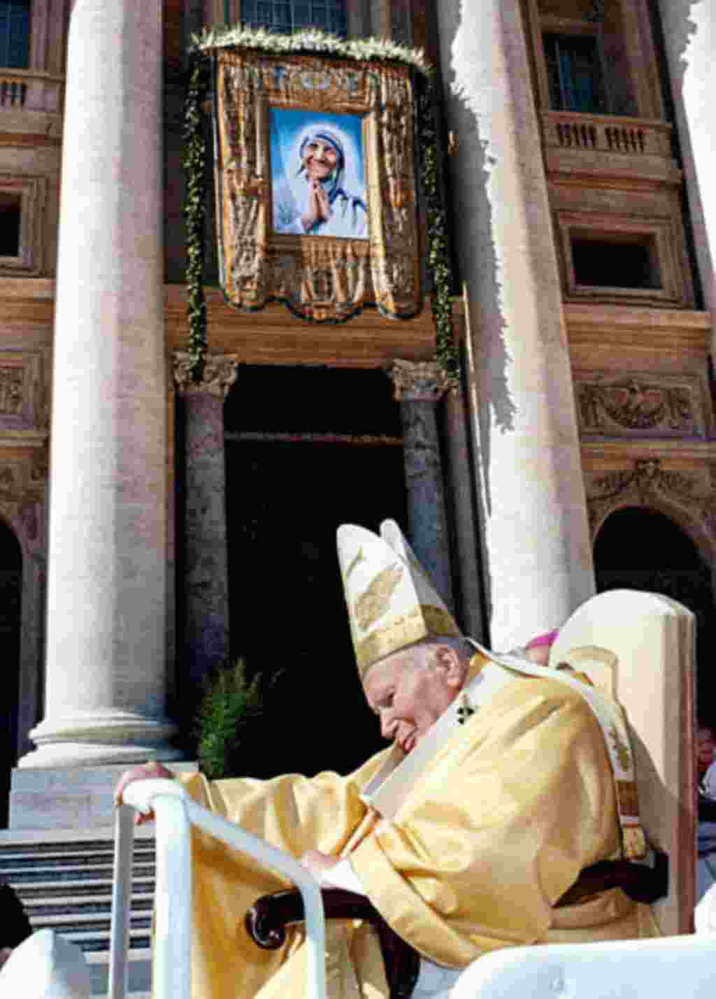 El Papa Juan Pablo II atraviesa delante de una imagen de la Madre Teresa de Calcuta sobre la fachaza de la Basílica de San Pedro, en el Vaticano.