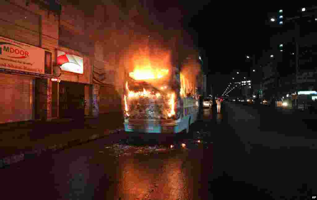 A bus stands in flames after it was set afire by opposition supporters trying to defy a ban on protests, in Dhaka, Bangladesh. The government has banned rallies in some parts of the country, fearing violence as the opposition gears up for street protests.