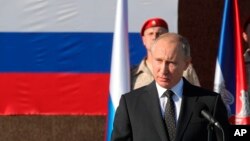 Le président russe Vladimir Poutine s'adresse aux troupes de la base aérienne de Hemeimeem en Syrie, le lundi 11 décembre 2017.