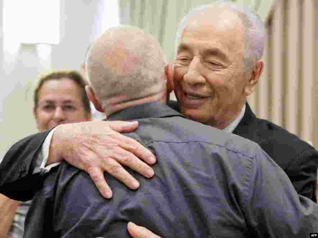 Israeli President Shimon Peres hugs Noam Shalit, father of captured Israeli soldier Gilad Schalit, at the president's residence in Jerusalem, October 12, 2011. Israel and Gaza's Hamas Islamist rulers agreed on Tuesday to swap more than 1,000 Palestinian p