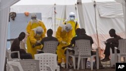 Petuga kesehatan memeriksa kondisi para penderita Ebola di sebuah klinik di Monrovia, Liberia (8/9).