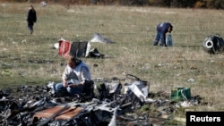 Para petugas mencari beberapa barang bukti di lokasi jatuhnya MH17 di dekat desa Hrabove, wilayah Donetsk, Ukraina Timur (13/10).