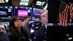 Specialist Erica Fredrickson works with a colleague on the floor of the New York Stock Exchange, Monday, Feb. 24, 2020. Stocks are opening sharply lower on Wall Street, pushing the Dow Jones Industrial Average down more than 700 points, as virus…