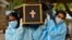 Volunteers carry the body of a person who died from the coronavirus disease (COVID-19) for burial at a cemetery in Bengaluru, India, May 18, 2021. 