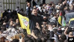 Palestinian mourners shout slogans as they carry the body Palestinian man Omar Kawasmeh during his funeral in the West Bank city of Hebron. Israeli troops mistakenly shot and killed a 65-year-old Palestinian man Friday during a predawn raid to arrest a Ha