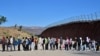 TOPSHOT - Migrants wait in line hoping for processing from Customs and Border Patrol agents after groups arrived at Jacumba Hot Springs, California, after walking under intense heat from Mexico into the US on June 5, 2024.