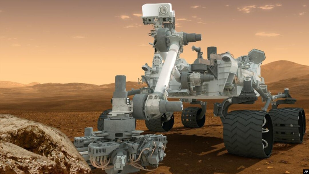 Gambaran kendaraan penjelajah NASA, Curiosity, di permukaan Mars. 