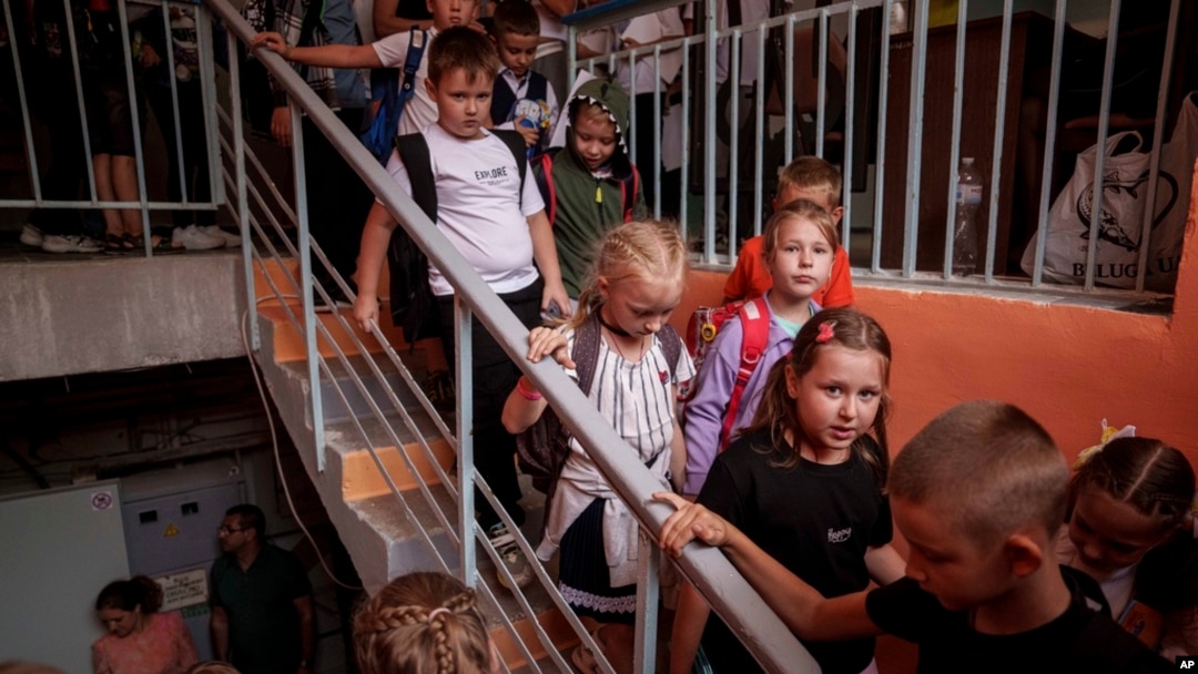 FILE - Children from Gymnasium No. 6 head to a basement set up with classrooms during an air alert in Zaporizhzhia, Ukraine, Sept. 3, 2024. 