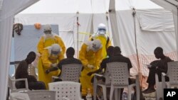 Petugas kesehatan merawat pasien-pasien yang terkena virus Ebola di sebuah klinik di Monrovia, Liberia (8/9). (AP/Abbas Dulleh)