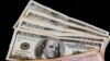 FILE - U.S. dollar bills and Argentine pesos are displayed for the photographer on a table at a currency exchange business in Buenos Aires, Argentina, Jan. 23, 2014.