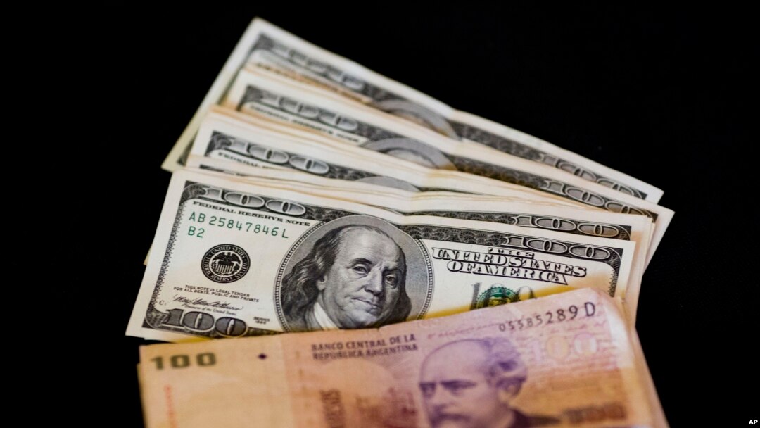Mata uang dolar AS dan peso Argentina di atas meja di bisnis penukaran mata uang di Buenos Aires, Argentina, 23 Januari 2014 (Foto: AP)