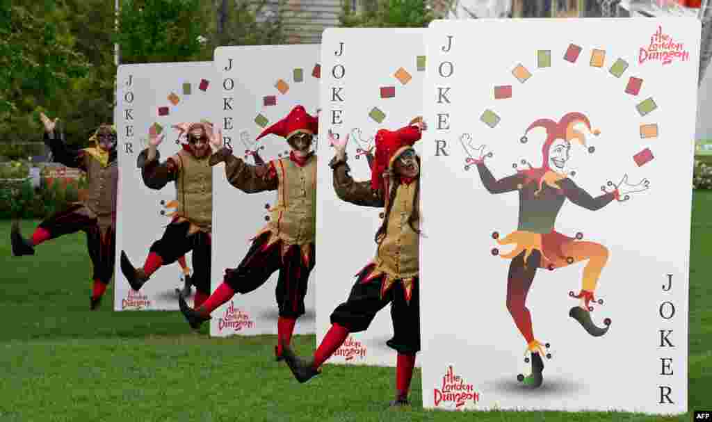 &#39;Black Jesters&#39; from the London Dungeon pose for pictures with a set of what the attraction describes as the world&#39;s biggest playing cards, during a photocall in London. The cards, which are 2.1m-tall and 1.5m-wide, will feature in the attraction&#39;s &#39;Jestival Season&#39;.
