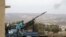 FILE - A rebel fighter from the Ahrar al-Sham Islamic Movement fires an anti-aircraft weapon towards what they said was a helicopter belonging to forces loyal to Syria's President Bashar al-Assad in Jabal al-Zawiya in the southern countryside of Idlib. 