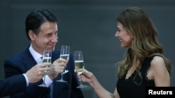 Argentina's first lady Juliana Awada toasts with Italian Prime Minister Giuseppe Conte during arrivals ahead of the G-20 leaders summit in Buenos Aires, Argentina, Nov. 29, 2018.
