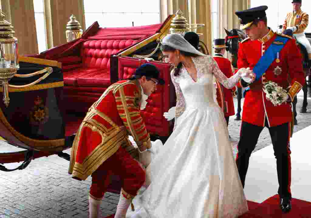 Pangeran William dan istrinya Catherine, turun dari kereta kerajaan Inggris yang digunakan sejak 1902, setibanya di istana Buckingham setelah pernikahan mereka di London, Inggris, 29 April 2011 (Reuters)