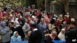 Oy kullanmak için kuyrukta bekleyen Mısırlı kadınlar