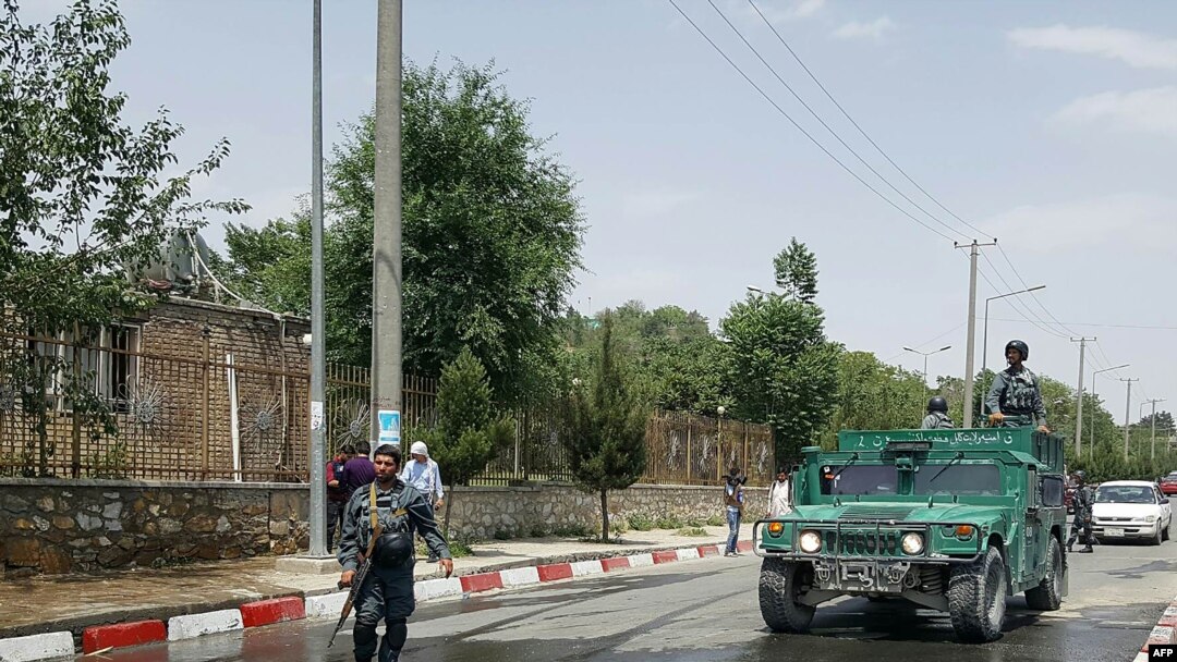 FILE - Afghan policemen stand guard at the gate of one of Kabul's universities, June 4, 2018.