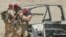 FILE: British soldiers take up position behind the wreckage of a vehicle in the village of Majar al-Kabir, Iraq, June 28, 2003. 