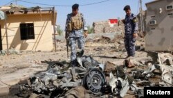 Policemen inspect the wreckage of a vehicle after a car bomb attack in Kirkuk, 250 kilometers north of Baghdad, Iraq, July 25, 2013.