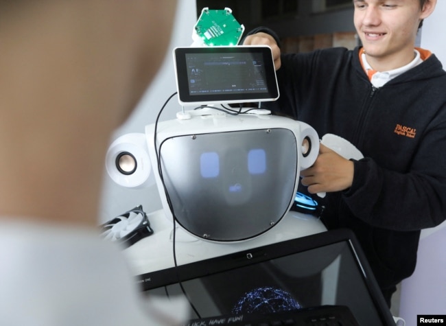 High school students Konstantinos Timinis and Vladimir Baranov work on "Alnstein", a robot powered by ChatGPT, in Pascal school in Nicosia, Cyprus on March 30, 2023. (REUTERS/Yiannis Kourtoglou)