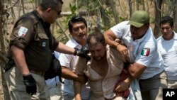 Un migrante centroamericano es detenido por agentes de inmigración mexicanos en la carretera hacia Pijijiapán, México, el lunes 22 de abril de 2019.