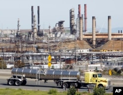 FILE - A tanker truck passes the Chevron oil refinery in Richmond, Calif.