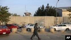 FILE - An Afghan security official patrols after an attack on the American University of Afghanistan in Kabul, Afghanistan, Aug. 25, 2016.