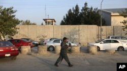 An Afghan security official is seen on foot patrol after an attack on the American University of Afghanistan in Kabul, Afghanistan, Aug. 25, 2016.