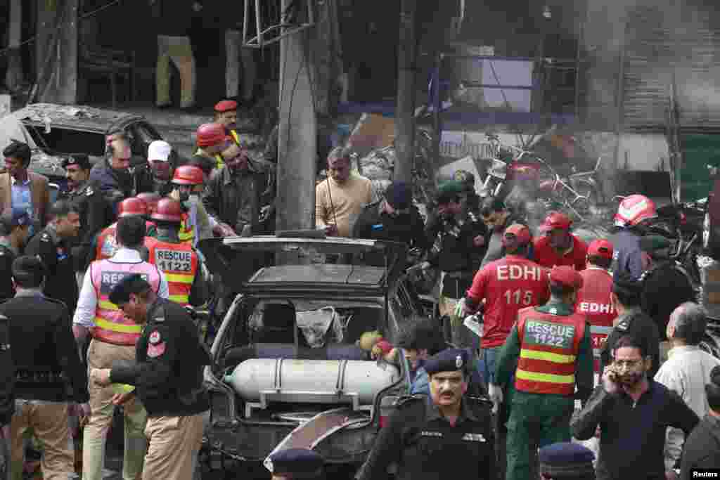 Policemen and residents gather at the site of an explosion outside the police headquarters, in Lahore, Pakistan, Feb. 17, 2015.